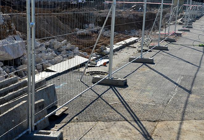 a row of temporary fence panels barricading a construction site